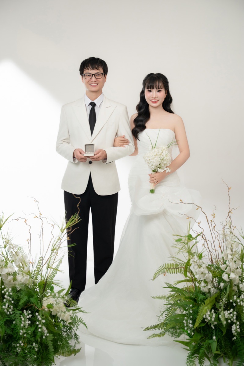 Tay trong tay cùng hộp nhẫn và hoa cưới